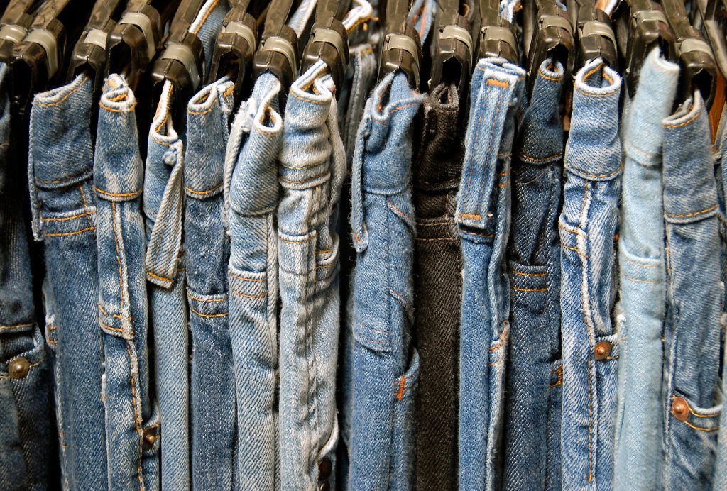 Jeans hanging on a rail.