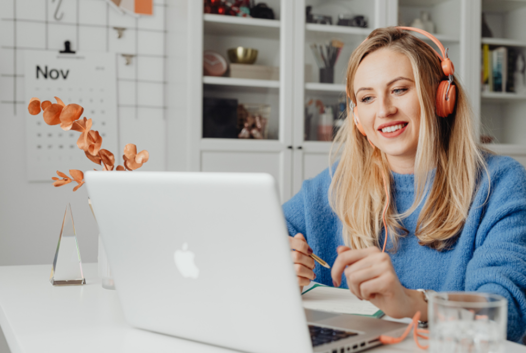Woman remote working at laptop with headphones.