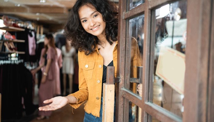 Shop worker welcoming customers into shop