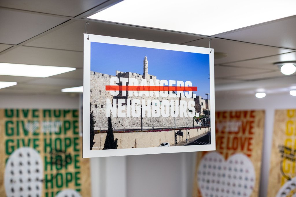 Sign stating 'neighbours, not strangers'.