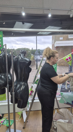 Window designer Penny McNeish surrounded by mannequins at Age UK Chadderton