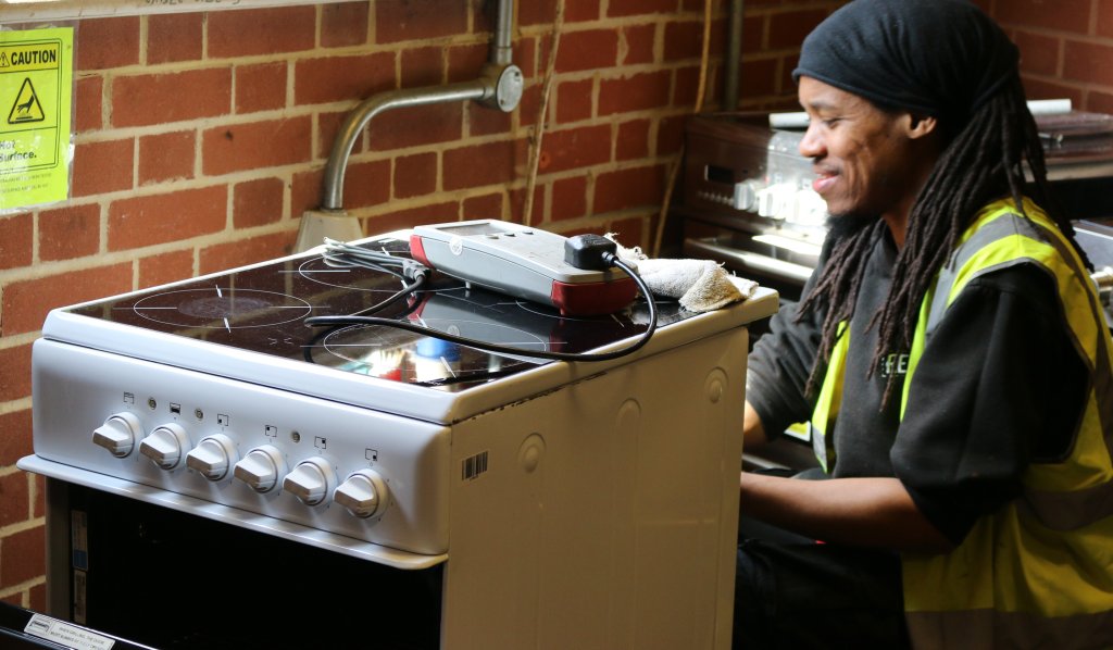 Person PAT testing an electric cooker.