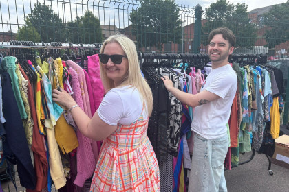 Staff pose with rails of clothes