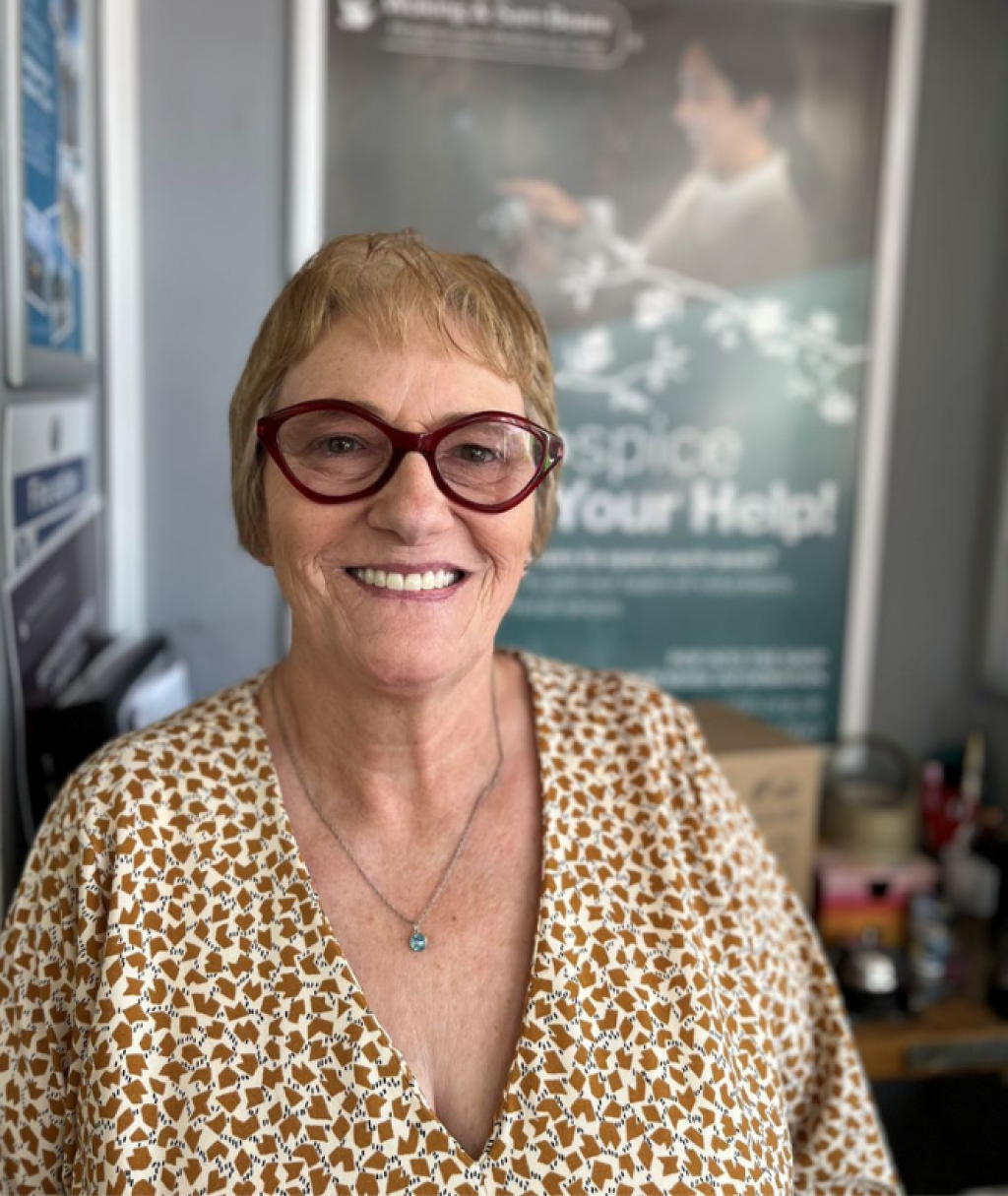 Smiling volunteer in a charity shop.