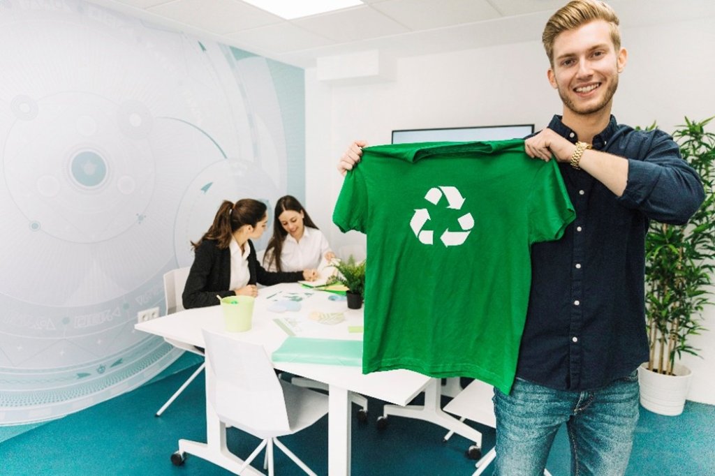 Person posing with green recycle logo t-shirt.