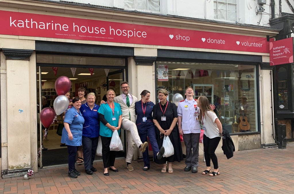 Happy people outside charity shop with donations.