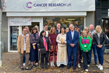 Shop team outside charity shop with award