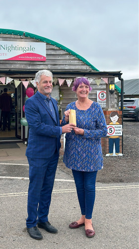 Award presentation taking place outside charity shop