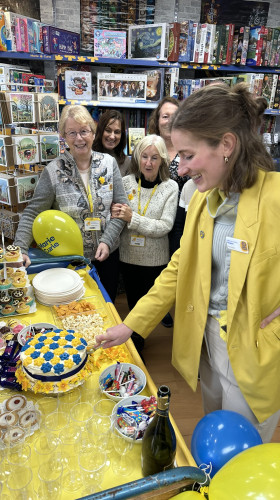 Shop manager cutting cake in shop celebrations
