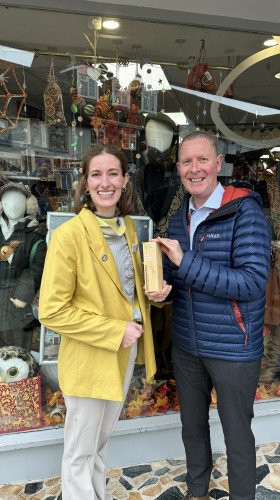 Award presentation taking place outside charity shop