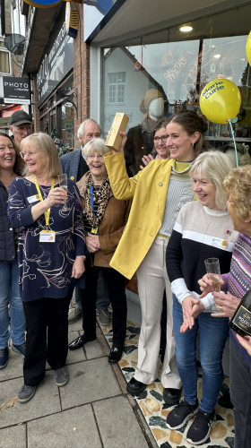 Charity shop team celebrate award outside shop