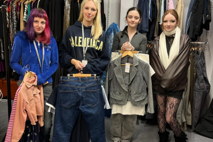 Four students from Bridgwater College holding a range of clothes in St Margaret’s Hospice charity shop, Taunton.